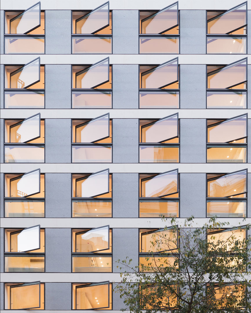 Vista frontal del edificio con ventanas móviles de metal y vidrio