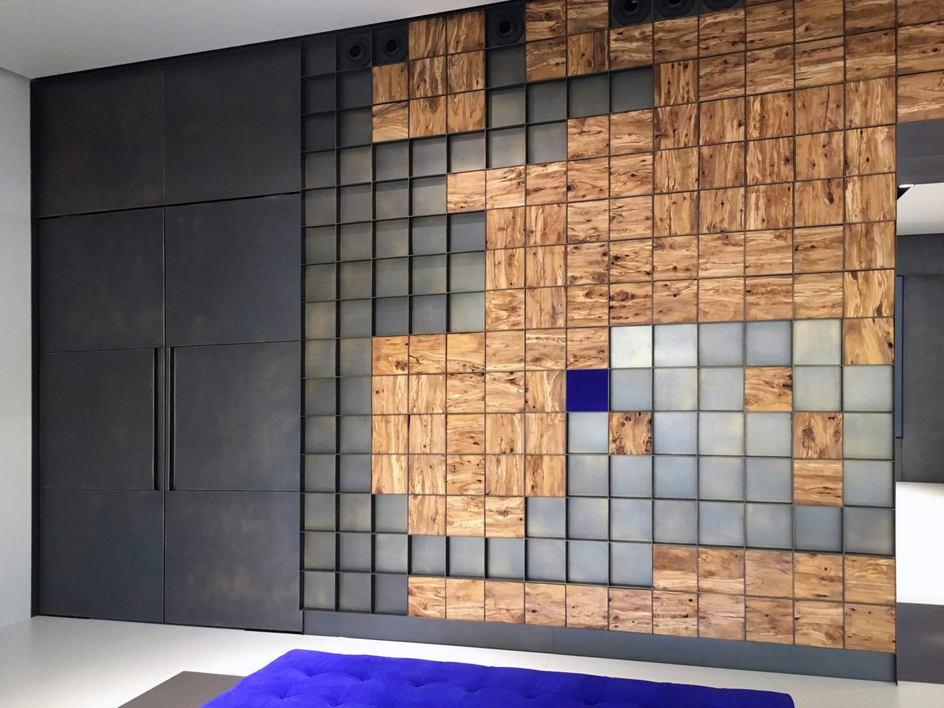 Vestíbulo con pared metálica y mapa del mundo hecho de cuadrados de madera