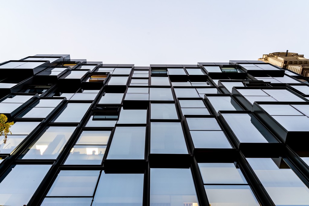 Fachada de un edificio con ventanas de vidrio y metal irregulares